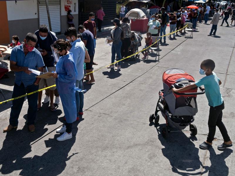 Asylum-seekers camping at El Chaparral crossing port line up to be vaccinated against COVID-19 last month in Tijuana, Mexico, on the border with the U.S. Asylum-seekers camping at El Chaparral crossing port line up to be vaccinated against COVID-19 last month in Tijuana, Mexico, on the border with the U.S.