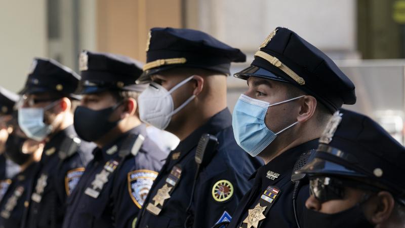 New York Police Department officers in masks stand during a service at St. Patrick's Cathedral in New York, last October. New York Police Department officers in masks stand during a service at St. Patrick's Cathedral in New York, last October.