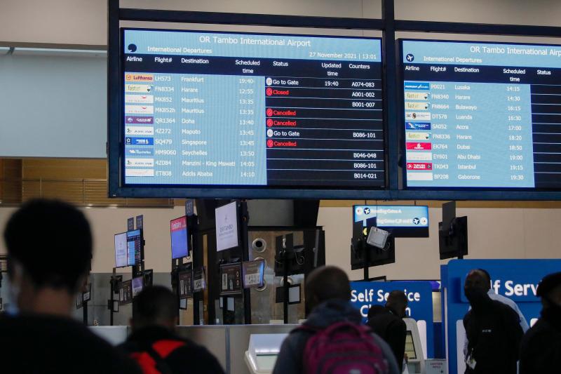 Travelers walk near an electronic flight notice board displaying canceled flights at O.R. Tambo International Airport in Johannesburg, South Africa, on Saturday. Several countries have begun travel bans in response to the omicron variant. Travelers walk near an electronic flight notice board displaying canceled flights at O.R. Tambo International Airport in Johannesburg, South Africa, on Saturday. Several countries have begun travel bans in response to the omicron variant.
