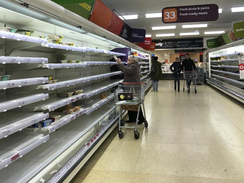 An elderly woman reaches up to a near empty shelf in a supermarket in London on Thursday. The coronavirus outbreak has led to panic shopping in the United Kingdom as elsewhere. An elderly woman reaches up to a near empty shelf in a supermarket in London on Thursday. The coronavirus outbreak has led to panic shopping in the United Kingdom as elsewhere.