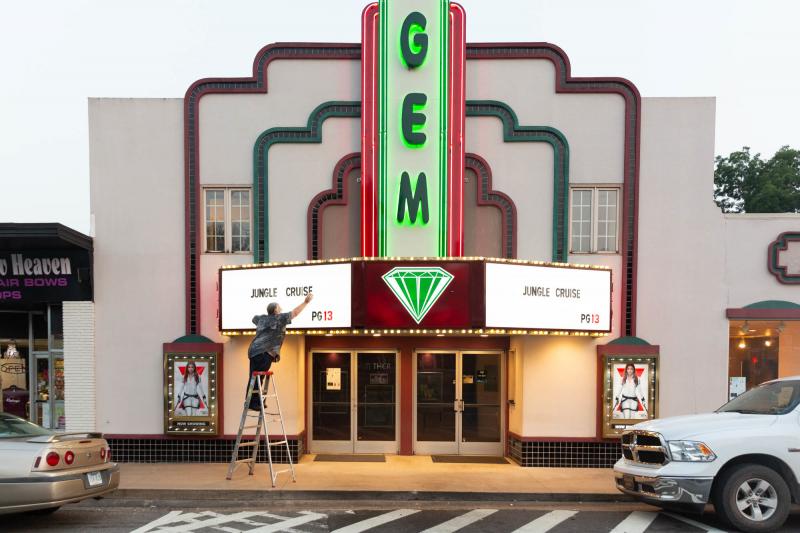 Kenny Nations, manager of the movie theater, changes the sign on the marquee; he is fully vaccinated and has tried to encourage co-workers to follow suit. Kenny Nations, manager of the movie theater, changes the sign on the marquee; he is fully vaccinated and has tried to encourage co-workers to follow suit.