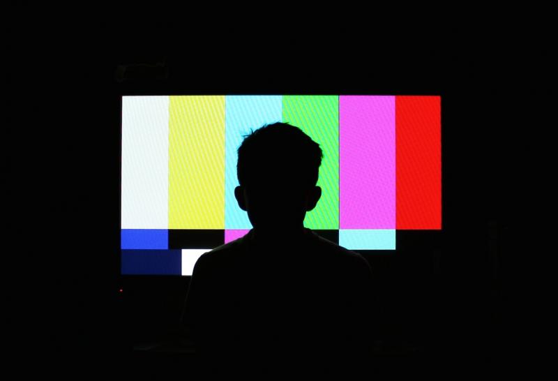 Silhouette of boy in front of a television screen. Silhouette of boy in front of a television screen.