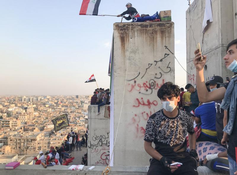 Demonstrators in Baghdad perch on top of an abandoned high-rise overlooking Tahrir Square. Demonstrators in Baghdad perch on top of an abandoned high-rise overlooking Tahrir Square.