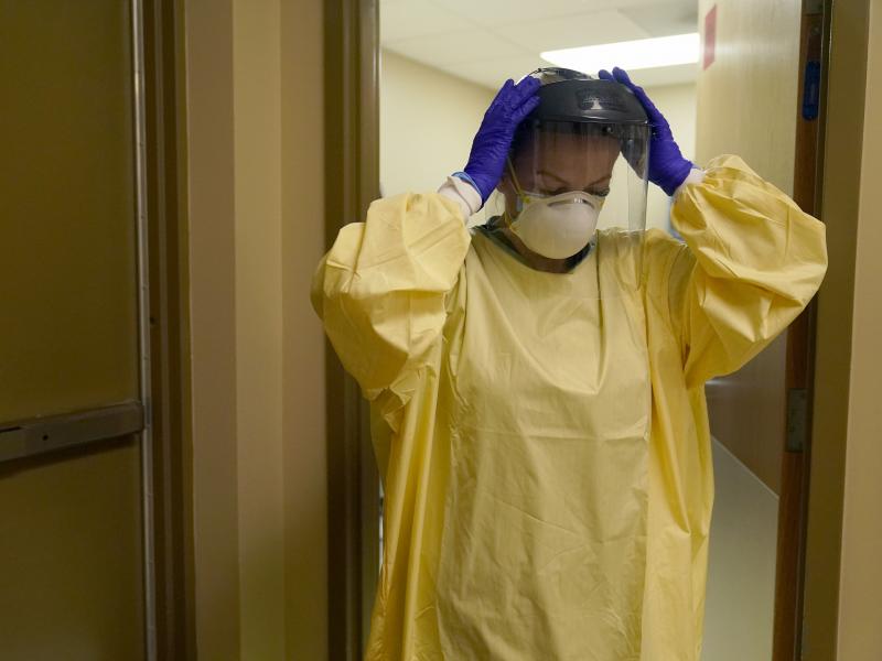 A nurse puts on personal protective equipment as she prepares to treat a COVID-19 patient last month at a rural Missouri hospital. A nurse puts on personal protective equipment as she prepares to treat a COVID-19 patient last month at a rural Missouri hospital.