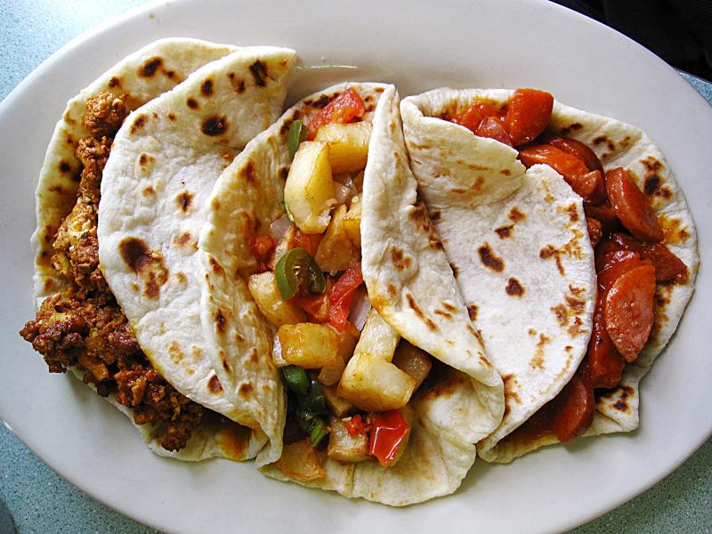 Chorizo and egg, papas rancheras and country guisado tacos on handmade flour tortillas from Mendez Cafe in San Antonio. Chorizo and egg, papas rancheras and country guisado tacos on handmade flour tortillas from Mendez Cafe in San Antonio.