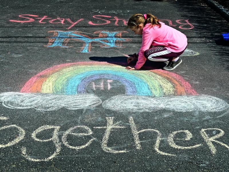 A girl makes chalk drawings on the driveway in West Islip, N.Y., in March 2020. A girl makes chalk drawings on the driveway in West Islip, N.Y., in March 2020.