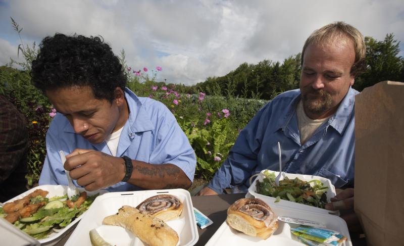Residents Julio Orsini and Jesse Mackin share a meal together with staff during lunch break in the garden at the Mountain View Correctional Faciltiy in Charleston Maine in August of 2021. Residents Julio Orsini and Jesse Mackin share a meal together with staff during lunch break in the garden at the Mountain View Correctional Faciltiy in Charleston Maine in August of 2021.