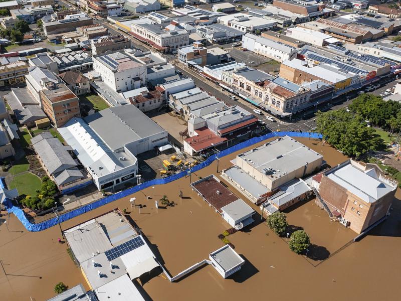 In this photo provided by the Fraser Coast Regional Council, a blue barrier helps hold back flood water in a section of Maryborough, Australia on Tuesday. In this photo provided by the Fraser Coast Regional Council, a blue barrier helps hold back flood water in a section of Maryborough, Australia on Tuesday.