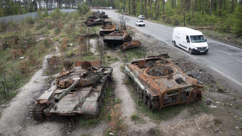 Cars pass destroyed Russian tanks from an earlier battle against Ukrainians in the village of Dmytrivka, close to Kyiv, Ukraine, on Monday. With Russian troops gone from the Kyiv region, life is returning to the city. But heavy fighting takes place daily Cars pass destroyed Russian tanks from an earlier battle against Ukrainians in the village of Dmytrivka, close to Kyiv, Ukraine, on Monday. With Russian troops gone from the Kyiv region, life is returning to the city. But heavy fighting takes place daily