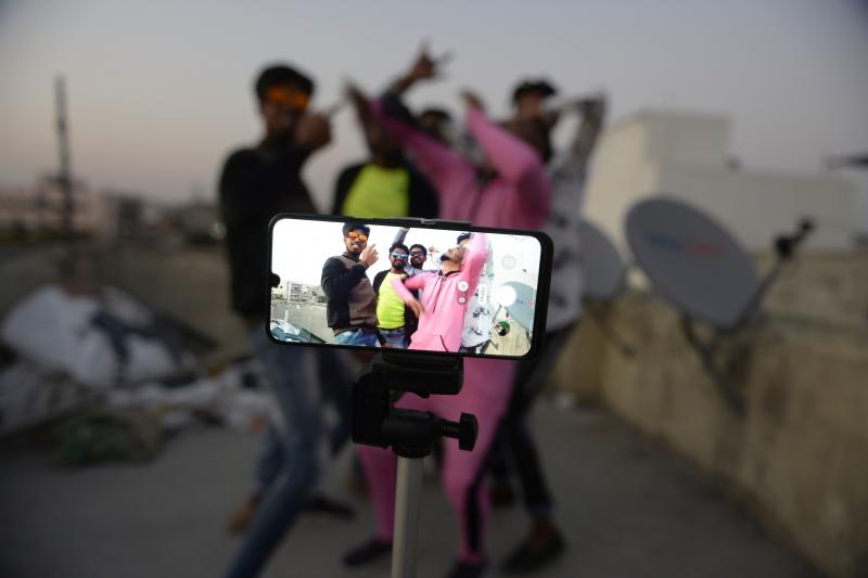 Youths perform in front of a cellphone camera while making a TikTok video on the roof of their residence in Hyderabad, India, in February. India's government has banned 59 Chinese-owned apps including TikTok. Youths perform in front of a cellphone camera while making a TikTok video on the roof of their residence in Hyderabad, India, in February. India's government has banned 59 Chinese-owned apps including TikTok.