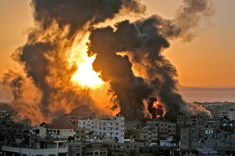 A fire rages at sunrise in the city of Khan Yunis following an Israeli airstrike in the southern Gaza Strip early on May 12. A fire rages at sunrise in the city of Khan Yunis following an Israeli airstrike in the southern Gaza Strip early on May 12.