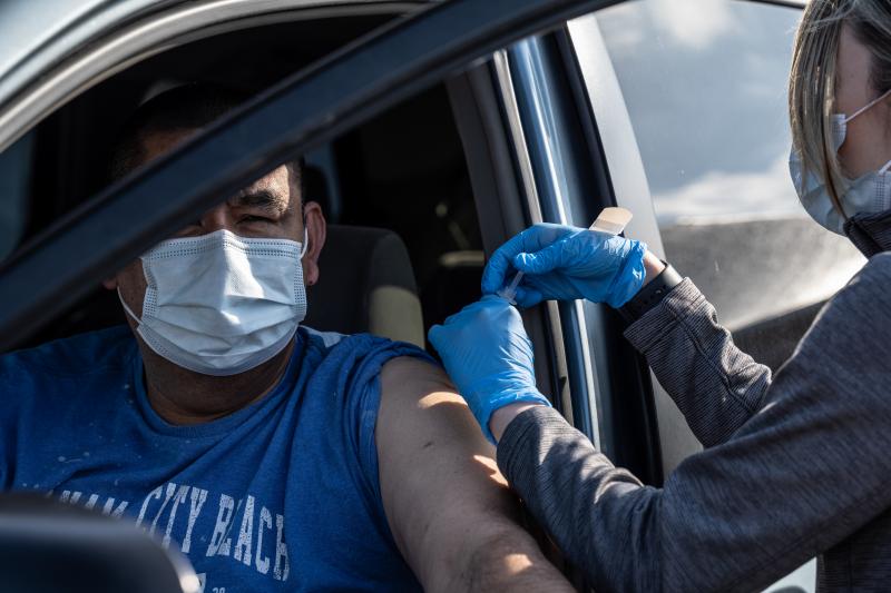A medical professional from UofL Health administers a vaccine to a patient in their vehicle at University of Louisville Cardinal Stadium. A medical professional from UofL Health administers a vaccine to a patient in their vehicle at University of Louisville Cardinal Stadium.