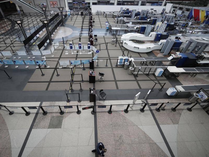 A lone passenger walks past the north checkpoint at Denver International Airport on April 1, which was closed because of a lack of traffic as a statewide stay-at-home order remains in effect to help reduce the spread of the coronavirus. A lone passenger walks past the north checkpoint at Denver International Airport on April 1, which was closed because of a lack of traffic as a statewide stay-at-home order remains in effect to help reduce the spread of the coronavirus.