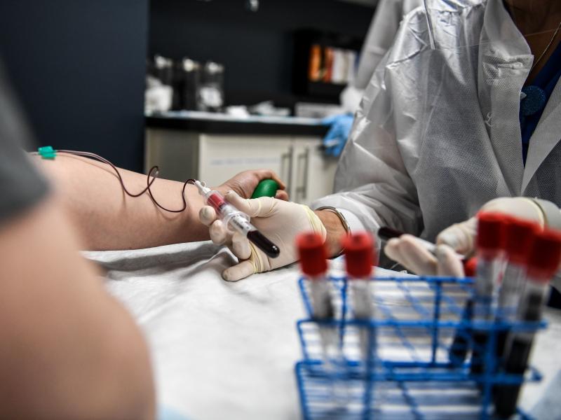 A researcher takes blood samples from a patient as she participates in a COVID-19 vaccine study last month at the Research Centers of America in Hollywood, Fla. A researcher takes blood samples from a patient as she participates in a COVID-19 vaccine study last month at the Research Centers of America in Hollywood, Fla.