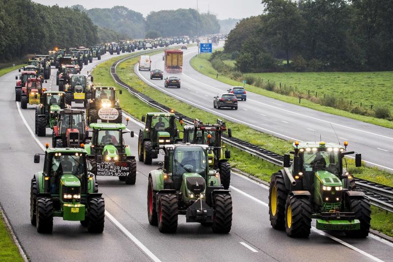 In the Netherlands, farmers block a major highway with their tractors on Tuesday during a national protest. Farmers say their livestock and operations are being unfairly blamed for greenhouse gas emissions. In the Netherlands, farmers block a major highway with their tractors on Tuesday during a national protest. Farmers say their livestock and operations are being unfairly blamed for greenhouse gas emissions.
