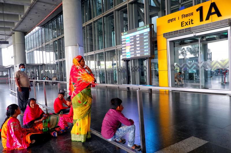 People wait at an exit gate at the Kolkata Airport Terminal. International air travel to and from India has been restricted as the country battles a catastrophic COVID-19 surge. People wait at an exit gate at the Kolkata Airport Terminal. International air travel to and from India has been restricted as the country battles a catastrophic COVID-19 surge.