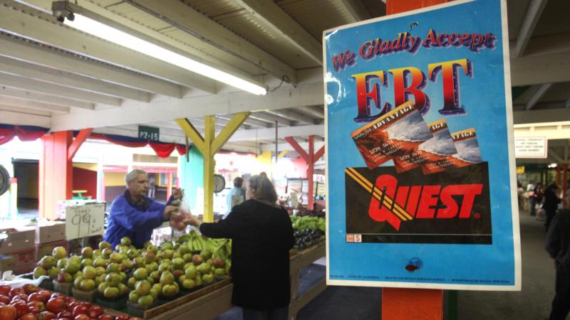 A sign announces the acceptance of electronic benefit transfer cards at a farmers market in California. Anti-poverty groups fear that many low-income people might be pushed off programs such as food stamps under a possible change to how the government mea A sign announces the acceptance of electronic benefit transfer cards at a farmers market in California. Anti-poverty groups fear that many low-income people might be pushed off programs such as food stamps under a possible change to how the government mea