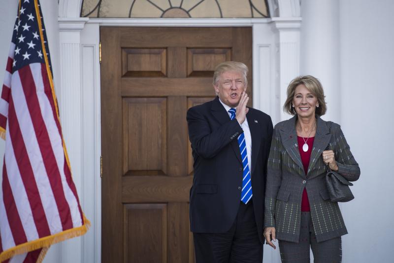 President-elect Donald Trump stands with Betsy DeVos after a meeting at Trump National Golf Club Bedminster in Bedminster Township, N.J., on Saturday. President-elect Donald Trump stands with Betsy DeVos after a meeting at Trump National Golf Club Bedminster in Bedminster Township, N.J., on Saturday.