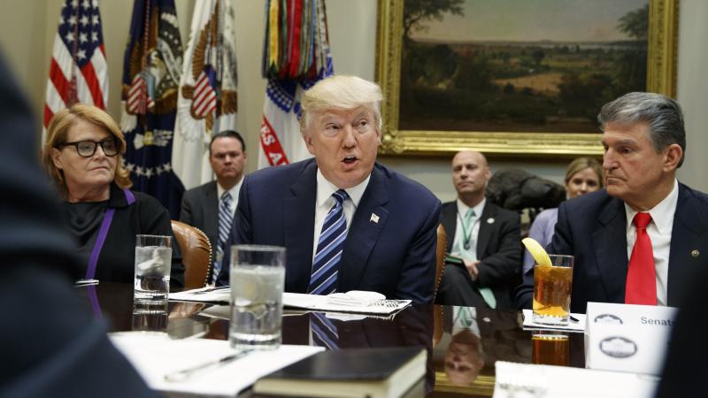 President Donald Trump, flanked by Sen. Heidi Heitkamp, D-N.D., (left) and Sen. Joe Manchin, D-W.Va., speaks during a meeting with senators on his Supreme Court Justice nominee Neil Gorsuch, on Feb. 9, 2017, in the Roosevelt Room of the White House. President Donald Trump, flanked by Sen. Heidi Heitkamp, D-N.D., (left) and Sen. Joe Manchin, D-W.Va., speaks during a meeting with senators on his Supreme Court Justice nominee Neil Gorsuch, on Feb. 9, 2017, in the Roosevelt Room of the White House.