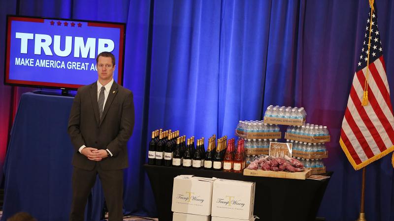 A security agent stands near a display of Trump-branded products that Republican presidential candidate Donald Trump had for guests, including meat, wine and water, before Trump's Tuesday night press conference after the Michigan and Mississippi primaries A security agent stands near a display of Trump-branded products that Republican presidential candidate Donald Trump had for guests, including meat, wine and water, before Trump's Tuesday night press conference after the Michigan and Mississippi primaries