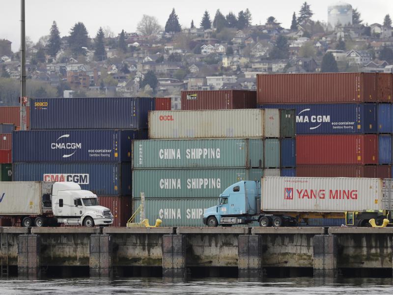 Trucks pass by cargo containers April 6 in Seattle. President Trump is preparing to impose tariffs on an additional $34 billion in Chinese imports on Friday, a move that China has promised to match. Trucks pass by cargo containers April 6 in Seattle. President Trump is preparing to impose tariffs on an additional $34 billion in Chinese imports on Friday, a move that China has promised to match.