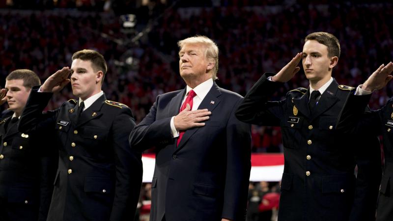 President Trump stands, with his hand over his heart, on the field for the national anthem before the start of the NCAA National Championship football game in January. President Trump stands, with his hand over his heart, on the field for the national anthem before the start of the NCAA National Championship football game in January.