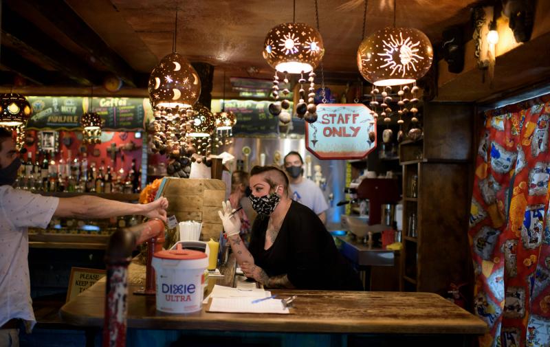 A bartender wearing a face mask and gloves checks a patron's ID at Under the Volcano in Houston last month. Texas is one of the states seeing a big uptick in coronavirus cases and hospitalizations. A bartender wearing a face mask and gloves checks a patron's ID at Under the Volcano in Houston last month. Texas is one of the states seeing a big uptick in coronavirus cases and hospitalizations.