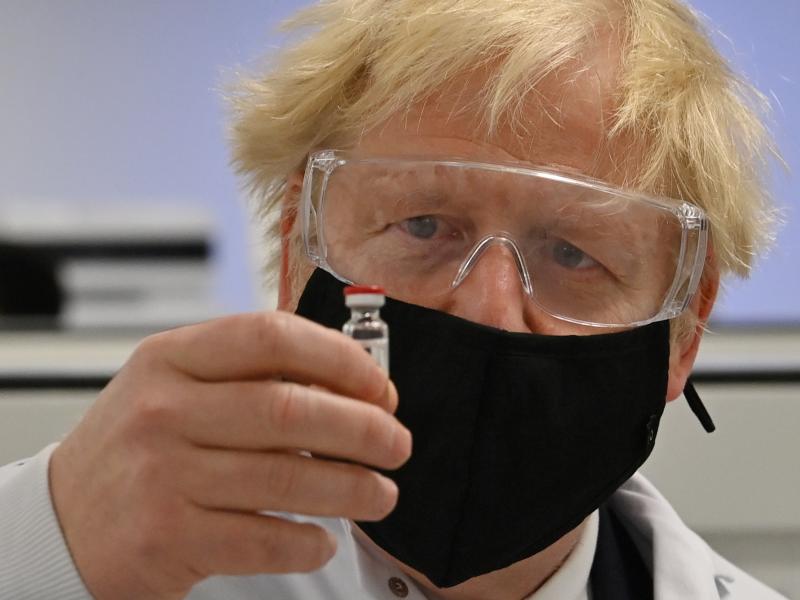 U.K. Prime Minister Boris Johnson looks at the newly authorized AstraZeneca/Oxford University COVID-19 vaccine. U.K. Prime Minister Boris Johnson looks at the newly authorized AstraZeneca/Oxford University COVID-19 vaccine.
