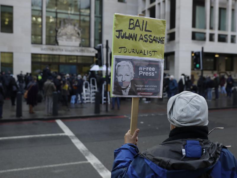 A Julian Assange supporter holds up a placard of the WikiLeaks founder outside Westminster Magistrates Court, the site of his bail hearing, in London on Wednesday. A Julian Assange supporter holds up a placard of the WikiLeaks founder outside Westminster Magistrates Court, the site of his bail hearing, in London on Wednesday.