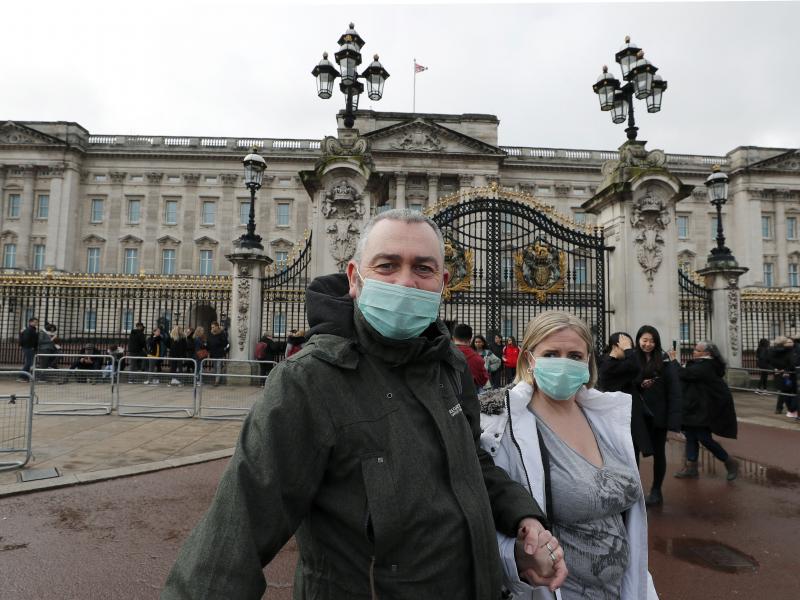 A couple wear face masks as they visit Buckingham Palace in London on Saturday. After criticism for responding slowly, the United Kingdom has urged the public to avoid unnecessary contact. A couple wear face masks as they visit Buckingham Palace in London on Saturday. After criticism for responding slowly, the United Kingdom has urged the public to avoid unnecessary contact.