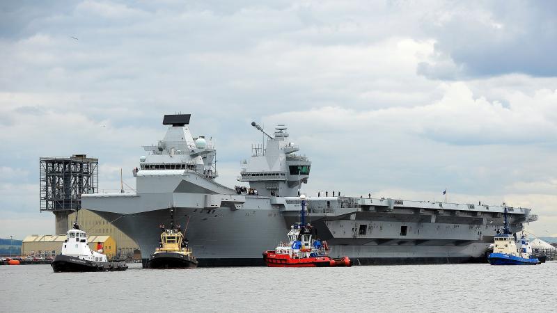 The HMS Queen Elizabeth, one of two brand-new British aircraft carriers, trails a collection of tug boats on the Firth of Forth in Scotland last month. U.K. Foreign Secretary Boris Johnson says the massive carriers, which have been billed as some of the b The HMS Queen Elizabeth, one of two brand-new British aircraft carriers, trails a collection of tug boats on the Firth of Forth in Scotland last month. U.K. Foreign Secretary Boris Johnson says the massive carriers, which have been billed as some of the b