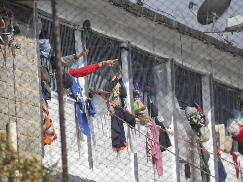 Inmates point from inside the La Modelo facility in Bogotá, Colombia, on Sunday. Violence broke out in the prison out of inmates' fears that prison guards are not doing enough to prevent coronavirus inside overcrowded prisons. Inmates point from inside the La Modelo facility in Bogotá, Colombia, on Sunday. Violence broke out in the prison out of inmates' fears that prison guards are not doing enough to prevent coronavirus inside overcrowded prisons.