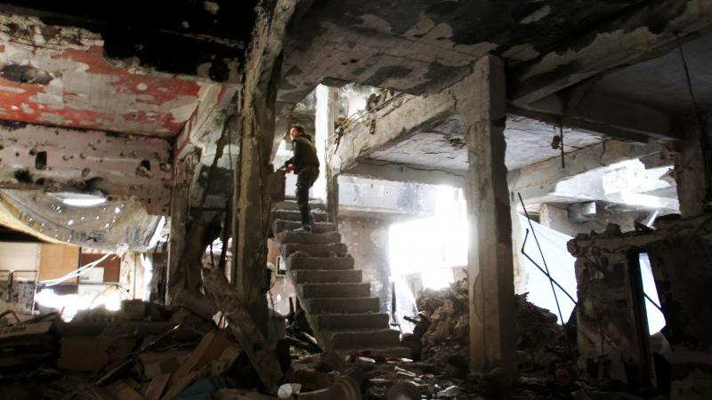 A man stands on a staircase inside a demolished building in the Yarmouk Palestinian refugee camp in the Syrian capital, Damascus, on Monday. A man stands on a staircase inside a demolished building in the Yarmouk Palestinian refugee camp in the Syrian capital, Damascus, on Monday.