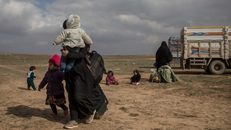Civilians who have fled fighting in Bagouz wait to board trucks after being screened by members of the Syrian Democratic Forces (SDF) at a makeshift screening point in the desert on Saturday in Bagouz, Syria. After weeks of fighting the SDF announced the Civilians who have fled fighting in Bagouz wait to board trucks after being screened by members of the Syrian Democratic Forces (SDF) at a makeshift screening point in the desert on Saturday in Bagouz, Syria. After weeks of fighting the SDF announced the