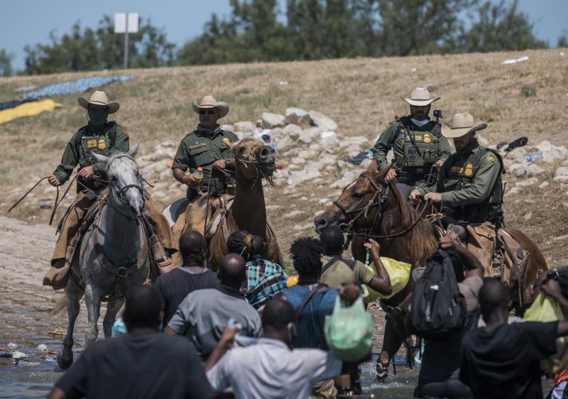 U.S. Customs and Border Protection mounted officers attempt to contain migrants as they cross the Rio Grande from Ciudad Acuña, Mexico, into Del Rio, Texas, on Sunday U.S. Customs and Border Protection mounted officers attempt to contain migrants as they cross the Rio Grande from Ciudad Acuña, Mexico, into Del Rio, Texas, on Sunday