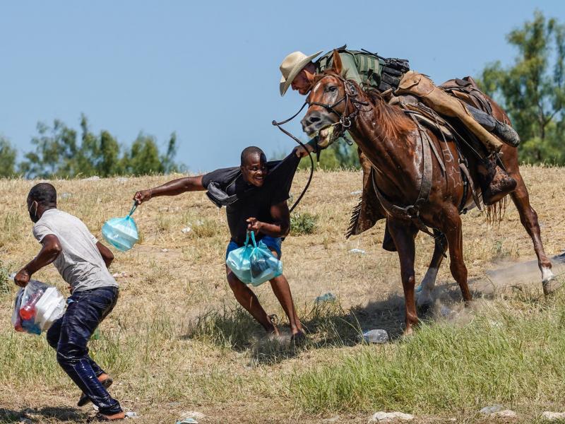 A U.S. Border Patrol agent on horseback tries to stop a Haitian migrant from entering an encampment on the banks of the Rio Grande on Sunday near the international bridge in Del Rio, Texas. A U.S. Border Patrol agent on horseback tries to stop a Haitian migrant from entering an encampment on the banks of the Rio Grande on Sunday near the international bridge in Del Rio, Texas.