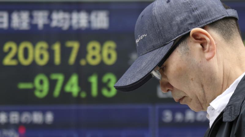 A man walks by an electronic stock board of a securities firm in Tokyo, on Friday. Asian stock markets slumped after Beijing responded to the Trump administration's tariff hikes by saying it may order higher import duties on a range of U.S. goods. A man walks by an electronic stock board of a securities firm in Tokyo, on Friday. Asian stock markets slumped after Beijing responded to the Trump administration's tariff hikes by saying it may order higher import duties on a range of U.S. goods.
