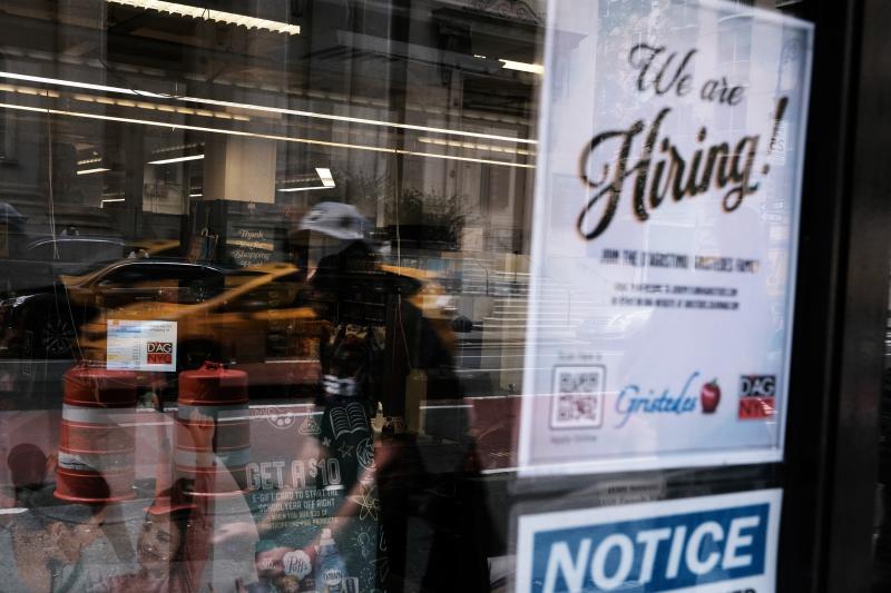 A hiring sign gets displayed in a store window in New York City in August. Last month saw a sharp slowdown in hiring from previous months as the pandemic wears on and creates uncertainty. A hiring sign gets displayed in a store window in New York City in August. Last month saw a sharp slowdown in hiring from previous months as the pandemic wears on and creates uncertainty.