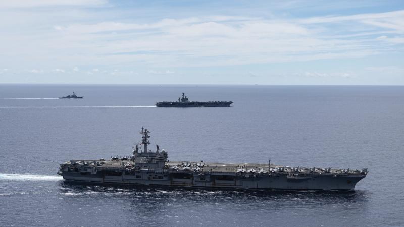 The USS Ronald Reagan (foreground) and the USS Nimitz Carrier Strike Groups sail together in formation in the South China Sea on July 6. China has accused the U.S. of flexing its military muscles by conducting joint exercises with two U.S. aircraft carrie The USS Ronald Reagan (foreground) and the USS Nimitz Carrier Strike Groups sail together in formation in the South China Sea on July 6. China has accused the U.S. of flexing its military muscles by conducting joint exercises with two U.S. aircraft carrie