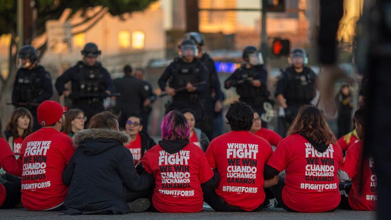 Police surround McDonald's restaurant employees who were sitting in an intersection in Los Angeles after walking off the job to demand a $15 minimum wage and union rights during nationwide "Fight for $15" protests on Tuesday. Police surround McDonald's restaurant employees who were sitting in an intersection in Los Angeles after walking off the job to demand a $15 minimum wage and union rights during nationwide "Fight for $15" protests on Tuesday.