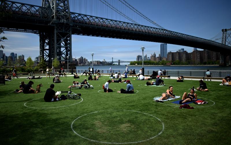 People relax in the sun while practicing social distancing last weekend in New York City's Domino Park. On Friday night, New York Gov. Andrew Cuomo issued an order loosening some of the state's coronavirus restrictions. People relax in the sun while practicing social distancing last weekend in New York City's Domino Park. On Friday night, New York Gov. Andrew Cuomo issued an order loosening some of the state's coronavirus restrictions.