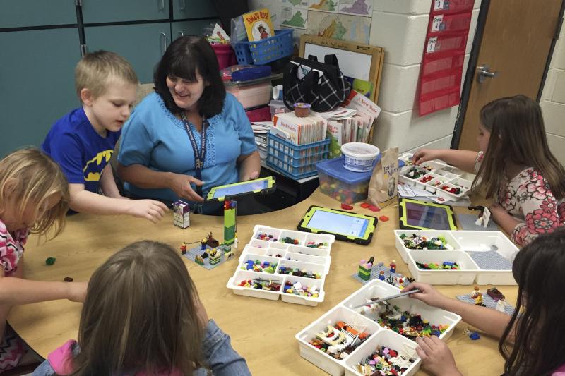 Anna Marie McClanahan (center) helps children write stories by using Legos to create scenes. Anna Marie McClanahan (center) helps children write stories by using Legos to create scenes.