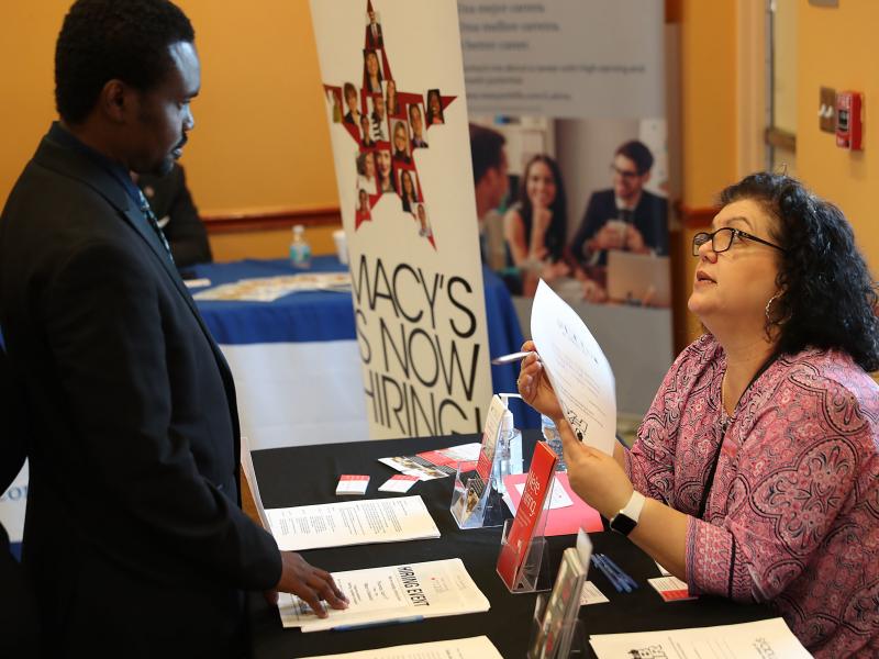Betty Fernandez of Macy's department store speaks with a potential applicant about job openings during a job fair in Miami on April 5. Employers added far more jobs than expected in April — another sign the U.S. economy is chugging along as the expansio Betty Fernandez of Macy's department store speaks with a potential applicant about job openings during a job fair in Miami on April 5. Employers added far more jobs than expected in April — another sign the U.S. economy is chugging along as the expansio