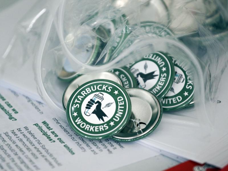 Pro-union pins sit on a table during a watch party for a Starbucks' employees union election on Dec. 9 in Buffalo, N.Y. Pro-union pins sit on a table during a watch party for a Starbucks' employees union election on Dec. 9 in Buffalo, N.Y.