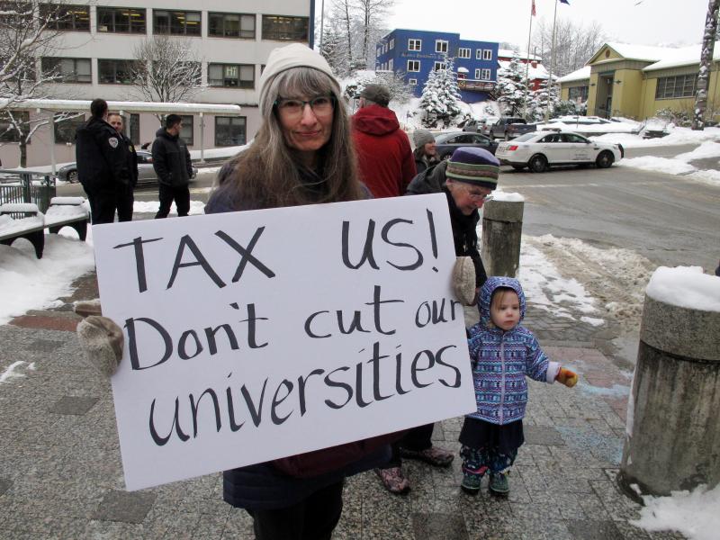 Luann McVey holds a sign before the start of a rally held in support of the Alaska university system on Feb. 13 in Juneau, Alaska. Luann McVey holds a sign before the start of a rally held in support of the Alaska university system on Feb. 13 in Juneau, Alaska.