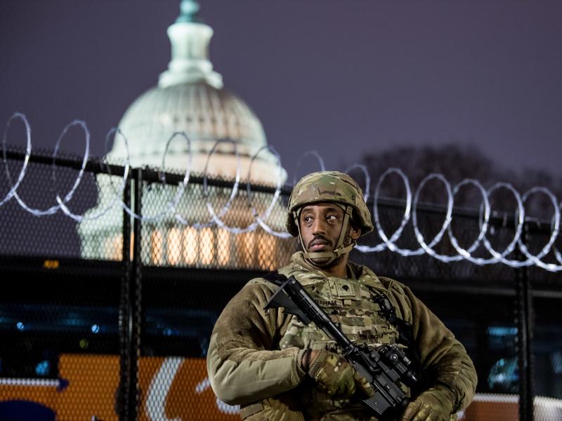 A member of the Virginia National Guard stands outside the razor wire fencing surrounding the U.S. Capitol on Friday. Up to 25,000 troops are expected by Inauguration Day. A member of the Virginia National Guard stands outside the razor wire fencing surrounding the U.S. Capitol on Friday. Up to 25,000 troops are expected by Inauguration Day.