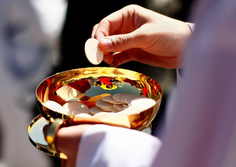 A priest holds a Holy Communion wafer in Washington, D.C. A priest holds a Holy Communion wafer in Washington, D.C.