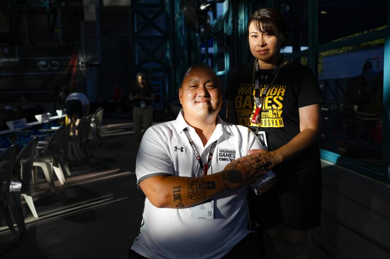 Retired Staff Sgt. Matt Lammers holds the hand of his wife, Alicia, before the swimming competition at the 2019 Department of Defense Warrior Games in Clearwater, Fla. Alicia has been Matt's official caregiver for nearly eight years, but she was cut from Retired Staff Sgt. Matt Lammers holds the hand of his wife, Alicia, before the swimming competition at the 2019 Department of Defense Warrior Games in Clearwater, Fla. Alicia has been Matt's official caregiver for nearly eight years, but she was cut from