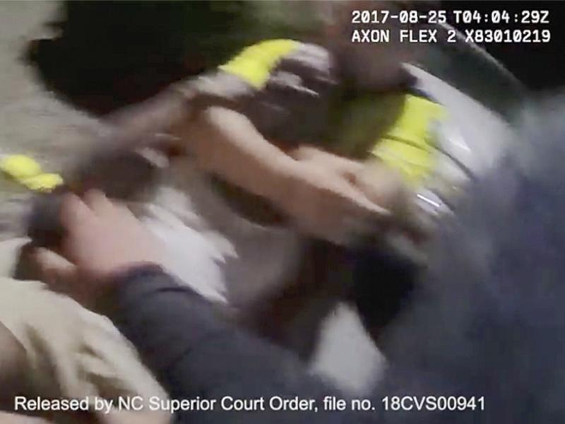 In this Aug. 25, 2017, image made from video and released by the Asheville, N.C., Police Department, Johnnie Jermaine Rush grimaces after officer Christopher Hickman overpowers Rush in a chokehold. Earlier this year, a shorter clip obtained by a newspaper In this Aug. 25, 2017, image made from video and released by the Asheville, N.C., Police Department, Johnnie Jermaine Rush grimaces after officer Christopher Hickman overpowers Rush in a chokehold. Earlier this year, a shorter clip obtained by a newspaper