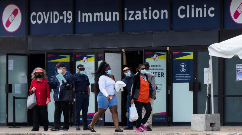 Canada's National Advisory Committee on Immunization is recommending allowing people to mix COVID-19 vaccine doses. Here, people walk past a vaccination clinic this week in Toronto. Canada's National Advisory Committee on Immunization is recommending allowing people to mix COVID-19 vaccine doses. Here, people walk past a vaccination clinic this week in Toronto.